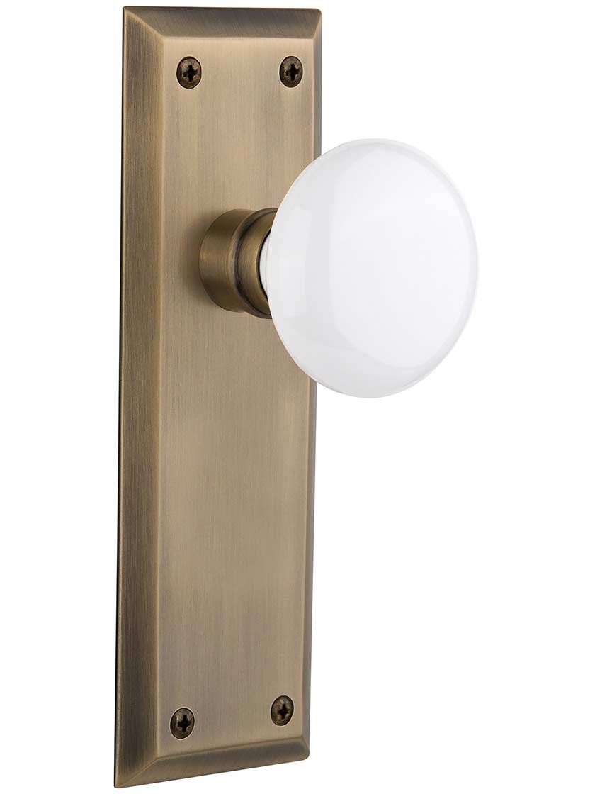 New York Door Set with White Porcelain Knobs in Antique Brass.